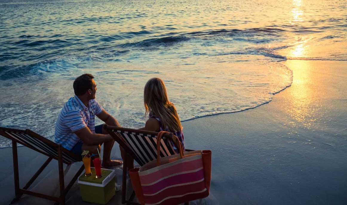 Couple sitting on the beach at Sunset